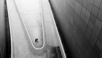A lonely couple coming through the amazing architecture shapes of Dongdaemun Desing Plaza in Seoul, South Korea.